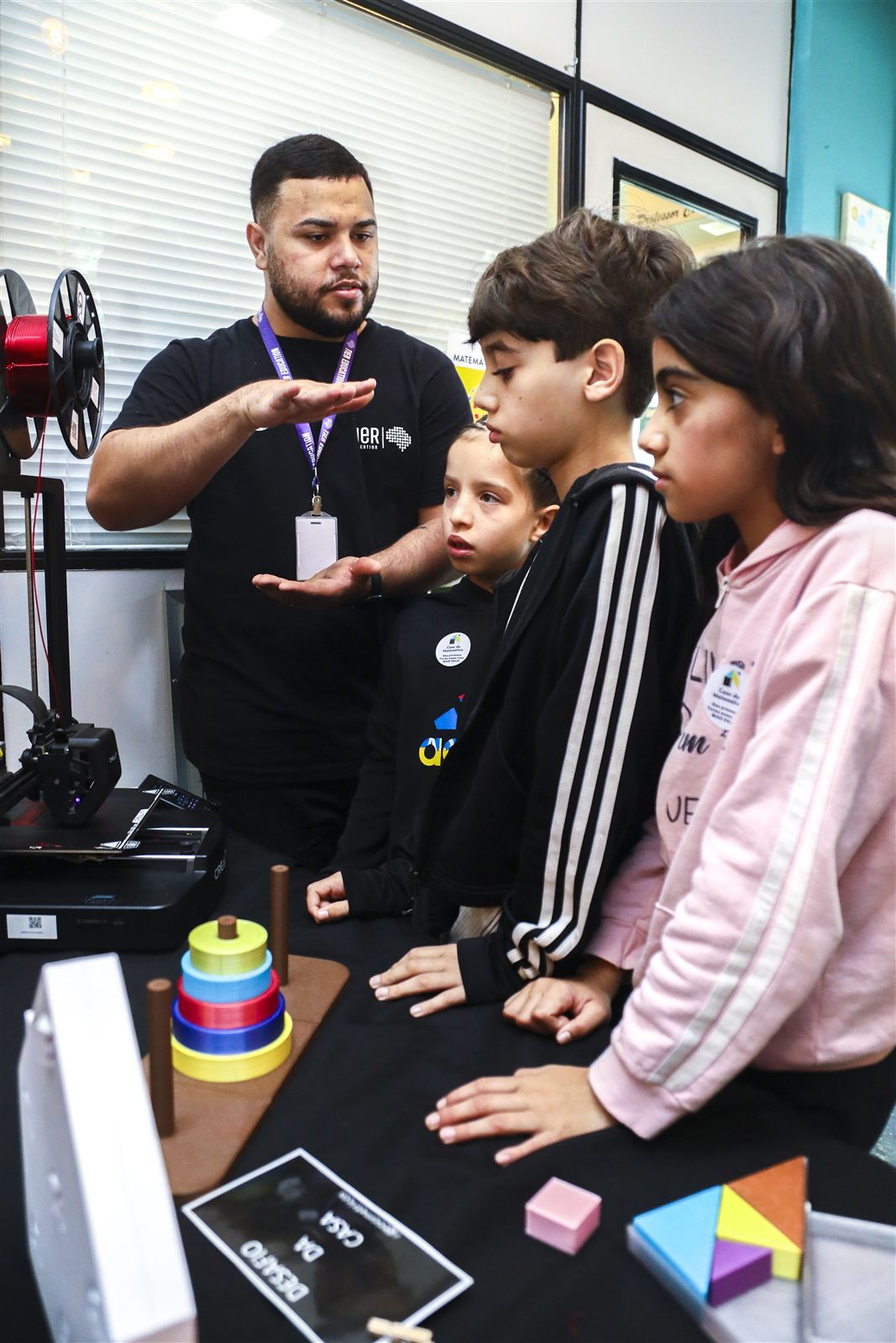 Educador apresentando impressão 3D a estudantes