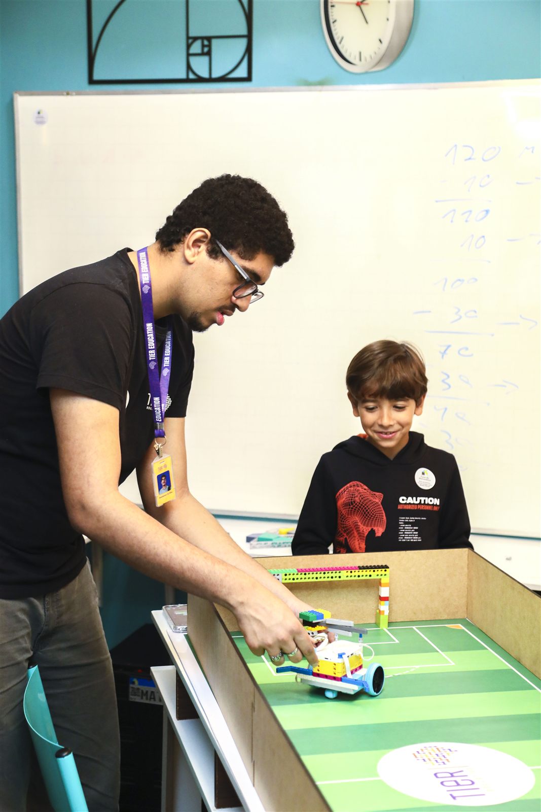 Educador TIER orientando uma atividade prática de robótica