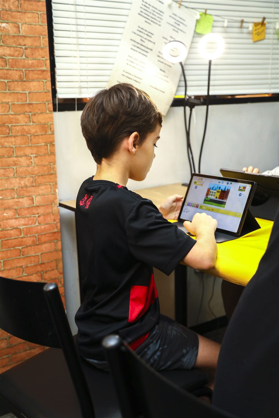 Estudante programando em um tablet durante uma aula